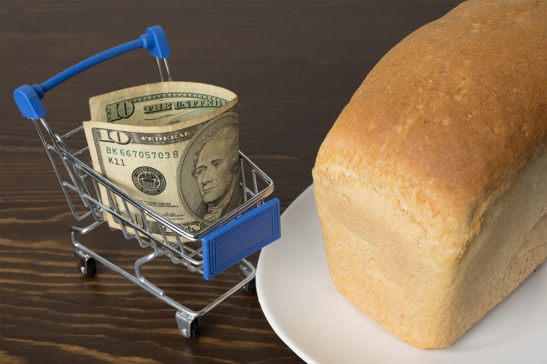 10 Dollars in a grocery basket with bread. Rising food prices and groceries in USA America and other countries. Humanitarian assistance GettyImages-1293339505